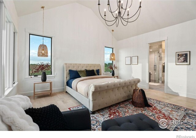 bedroom featuring multiple windows, ensuite bathroom, an inviting chandelier, and light hardwood / wood-style floors