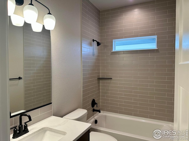 full bathroom featuring vanity, tiled shower / bath combo, and toilet