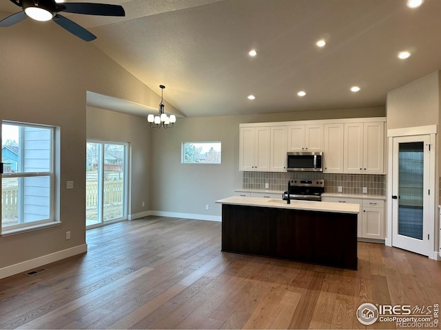3274 Buffalo Grass Ln, Wellington, CO 80549 - kitchen featuring appliances with stainless steel finishes, light countertops, tasteful backsplash, ceiling fan, and white cabinets