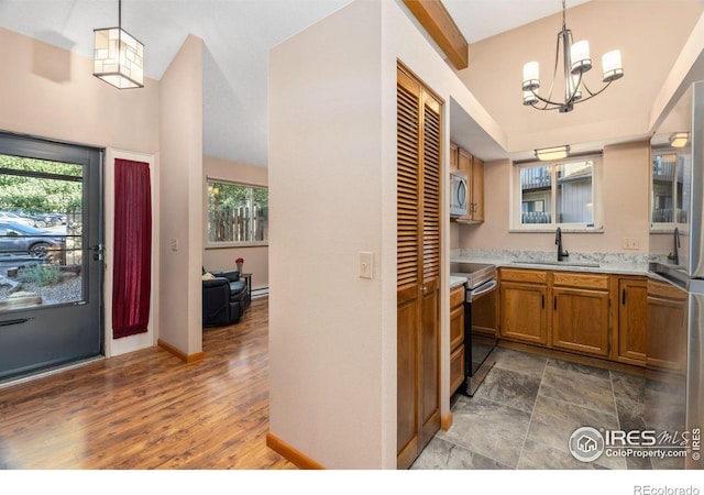 kitchen featuring hardwood / wood-style flooring, decorative light fixtures, sink, and appliances with stainless steel finishes