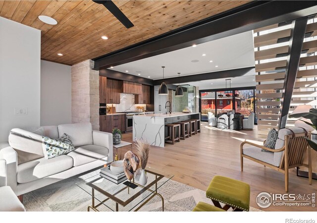 living room with sink, light hardwood / wood-style flooring, and wood ceiling