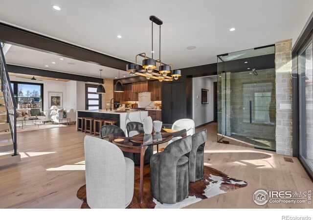 dining space featuring light hardwood / wood-style flooring and a chandelier