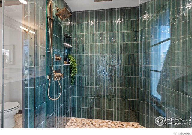 bathroom with tiled shower and toilet