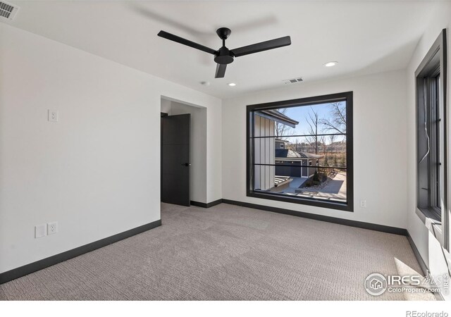 carpeted spare room featuring ceiling fan