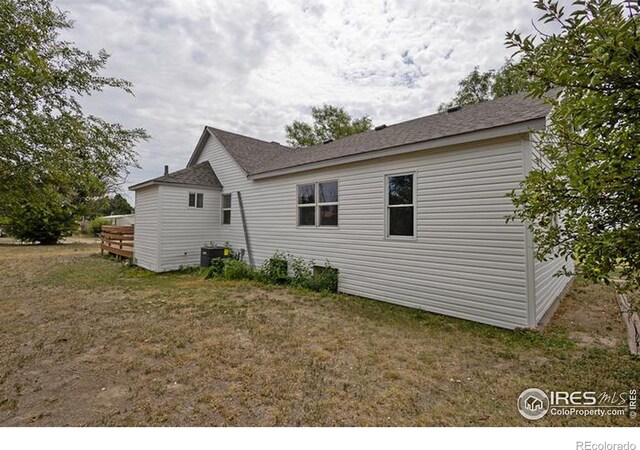 view of property exterior with central air condition unit and a yard