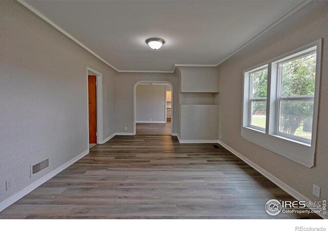 empty room featuring crown molding and hardwood / wood-style floors