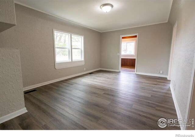 unfurnished room with hardwood / wood-style flooring, a healthy amount of sunlight, and ornamental molding