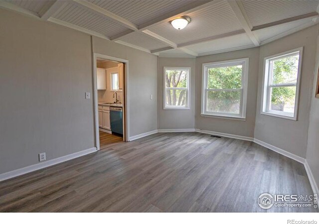 unfurnished bedroom featuring sink, beam ceiling, wood-type flooring, and coffered ceiling