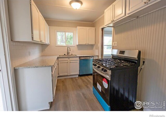 kitchen featuring light hardwood / wood-style flooring, white cabinetry, dishwasher, sink, and range with gas cooktop