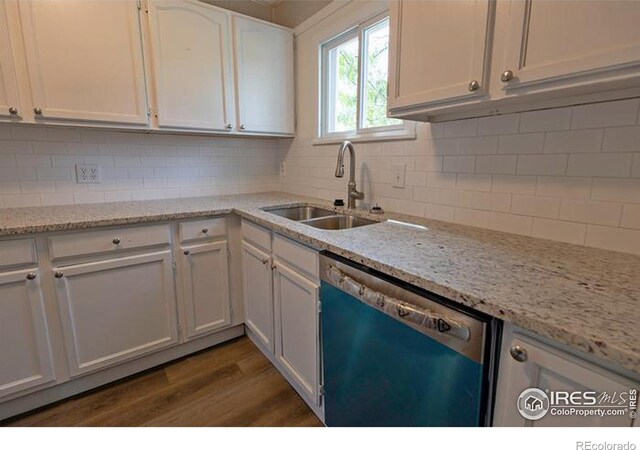 kitchen with hardwood / wood-style flooring, stainless steel dishwasher, backsplash, and sink