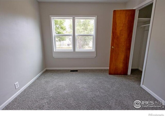 unfurnished bedroom with a closet and carpet flooring