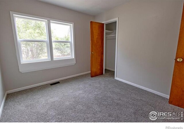 unfurnished bedroom featuring carpet and a closet