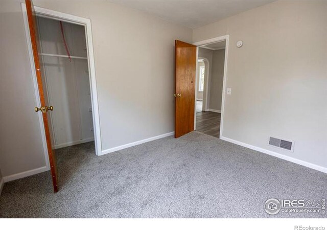 unfurnished bedroom featuring carpet floors and a closet