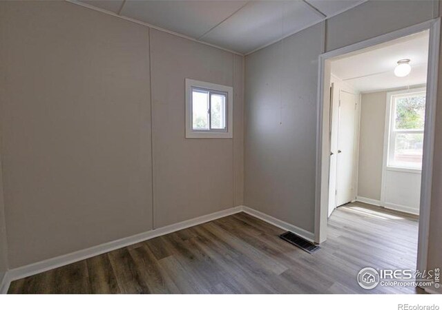 unfurnished room with a wealth of natural light and hardwood / wood-style floors