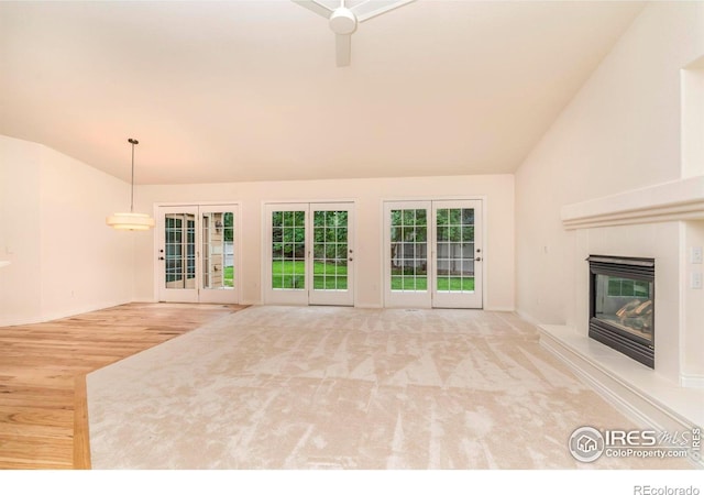 unfurnished living room with carpet floors, vaulted ceiling, and a tiled fireplace