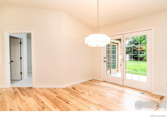 unfurnished room with wood finished floors, visible vents, and baseboards