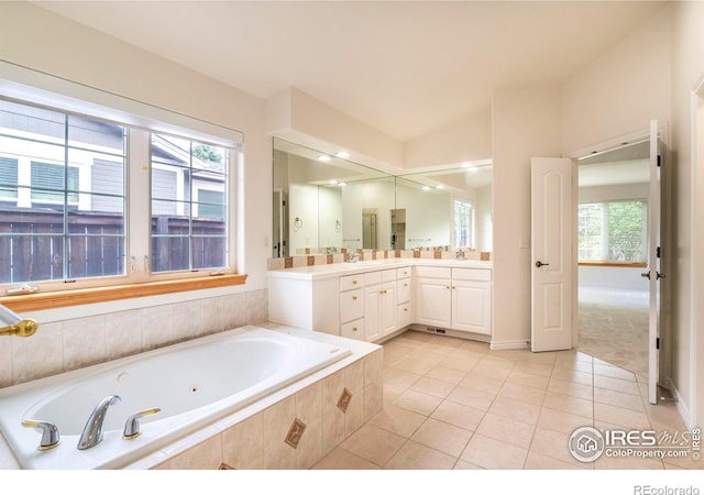 bathroom with tile patterned flooring, a garden tub, and vanity