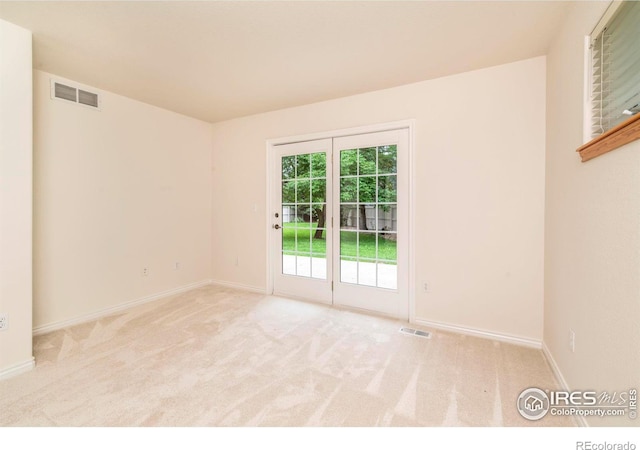 unfurnished room with baseboards, visible vents, and light colored carpet