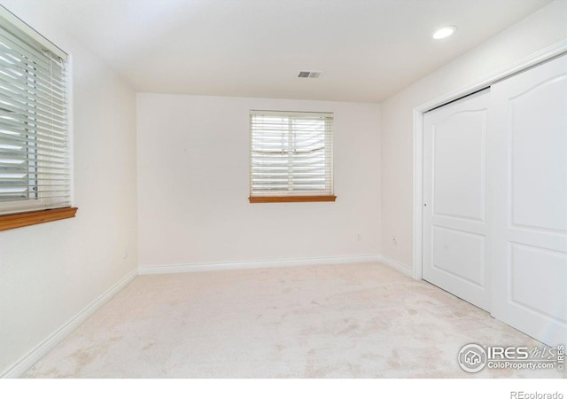 unfurnished bedroom featuring recessed lighting, visible vents, baseboards, and light colored carpet