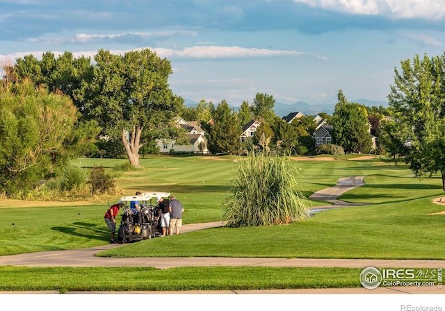 surrounding community featuring golf course view and a lawn