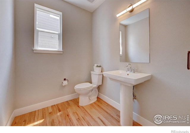 bathroom with hardwood / wood-style flooring and toilet