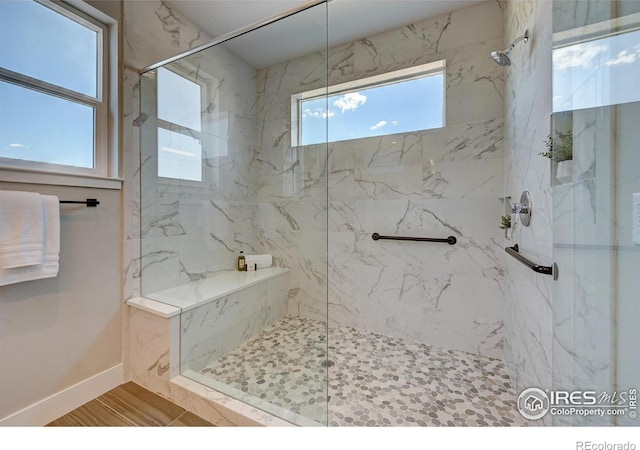 bathroom featuring wood-type flooring, plenty of natural light, and tiled shower