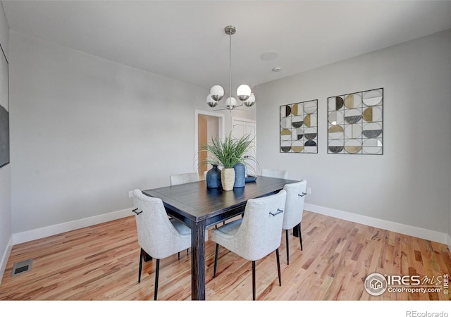 dining room with an inviting chandelier and light hardwood / wood-style flooring