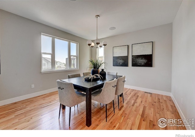 dining area with a chandelier and light hardwood / wood-style floors