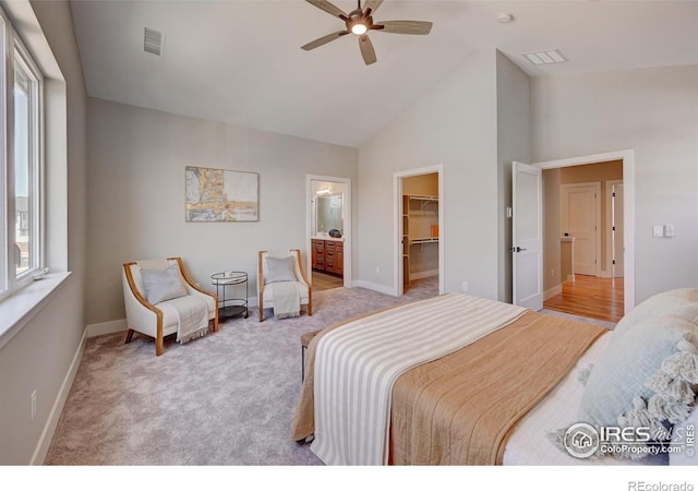 bedroom with ceiling fan, high vaulted ceiling, light carpet, a spacious closet, and a closet