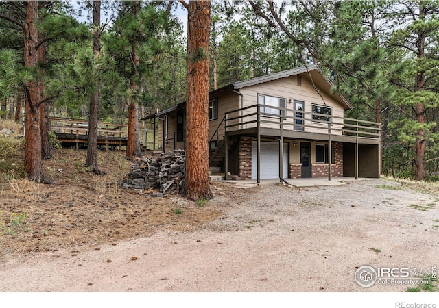 view of front property featuring a garage and a wooden deck