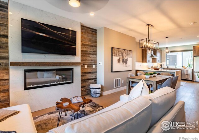 living room featuring sink, a large fireplace, and hardwood / wood-style floors