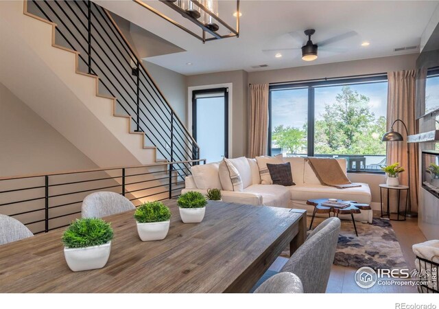 dining area featuring hardwood / wood-style flooring and ceiling fan with notable chandelier