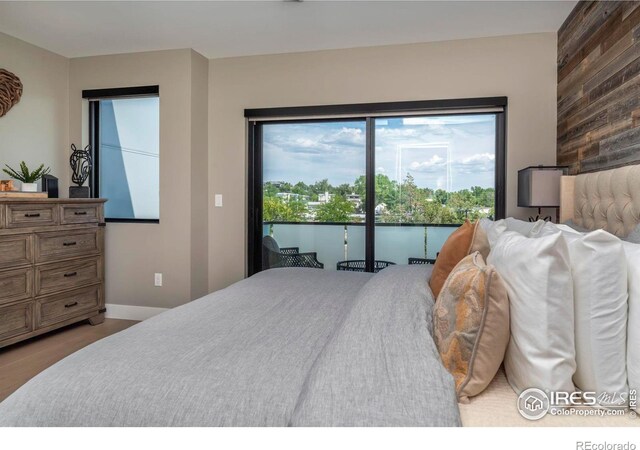 bedroom with access to outside and wooden walls