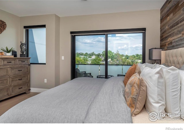 bedroom with wood walls, a water view, and baseboards