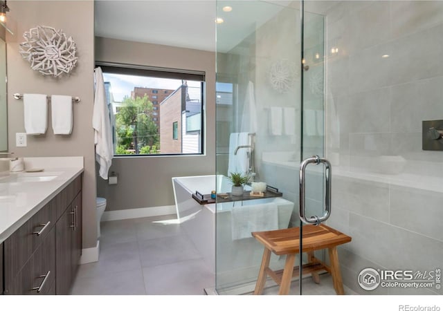 bathroom featuring a freestanding bath, toilet, a stall shower, vanity, and tile patterned flooring