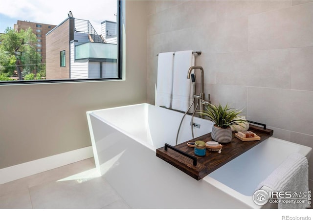 full bath with a freestanding tub and tile walls