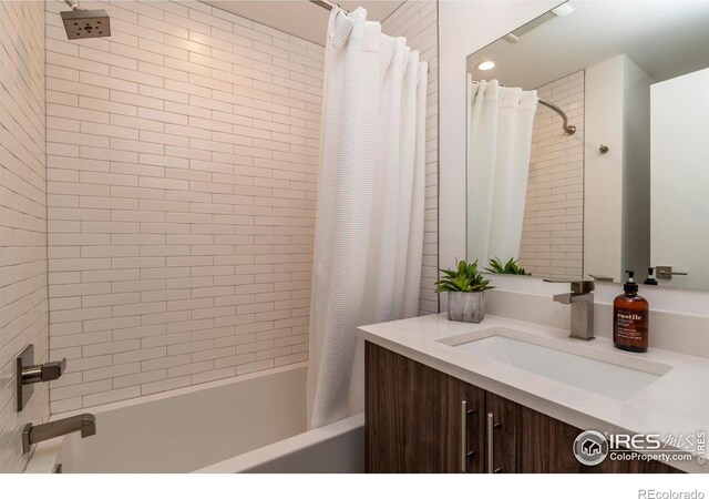 bathroom featuring vanity and shower / bathtub combination with curtain