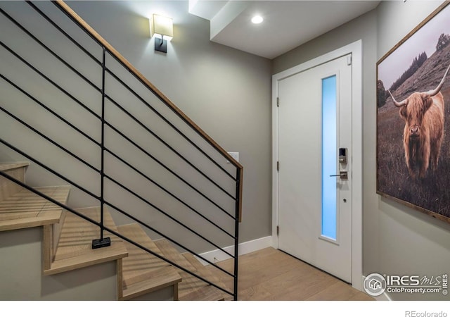 foyer with stairs, wood finished floors, and recessed lighting