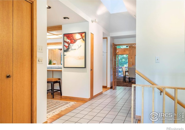 hallway featuring light tile patterned floors and baseboards