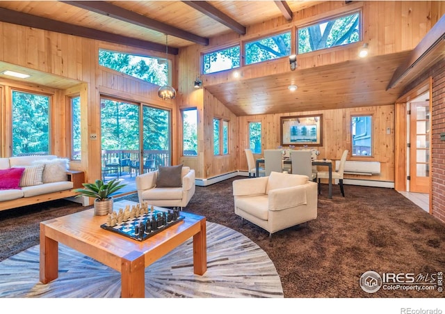 carpeted living room featuring beam ceiling, a towering ceiling, baseboard heating, wood ceiling, and wood walls