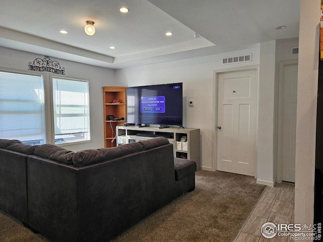 carpeted living room with a raised ceiling