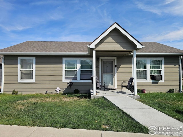 bungalow-style house featuring cooling unit and a front lawn