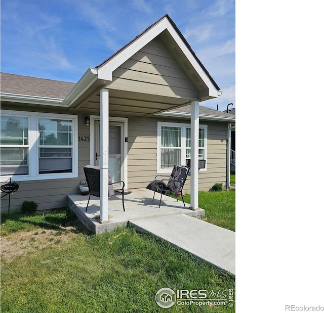 rear view of property featuring a lawn