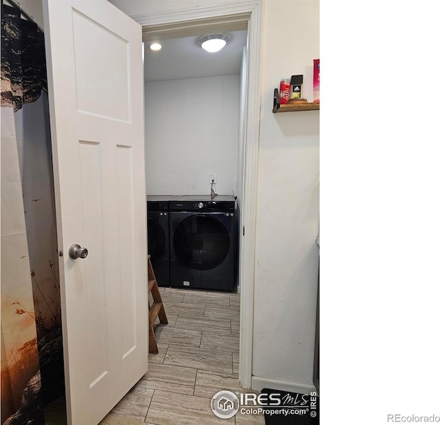 clothes washing area featuring light hardwood / wood-style floors and washer and dryer