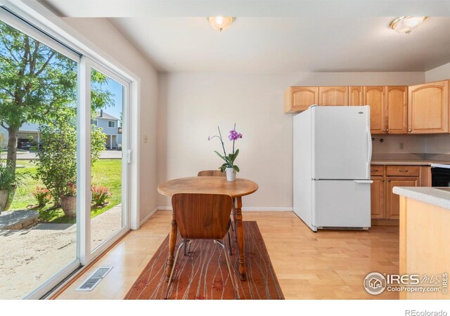 kitchen featuring light brown cabinetry, light hardwood / wood-style floors, and white refrigerator