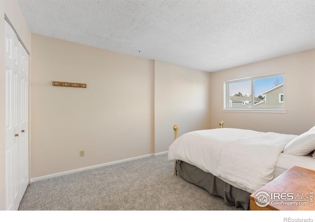 carpeted bedroom with a closet and a textured ceiling