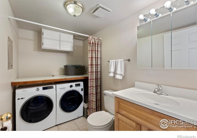 bathroom with tile patterned flooring, vanity, washing machine and dryer, and toilet