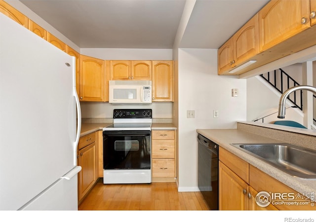 kitchen featuring sink, light brown cabinetry, white appliances, and light wood-type flooring