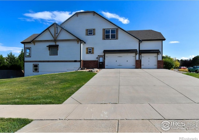 view of front of home with a front yard, brick siding, driveway, and an attached garage