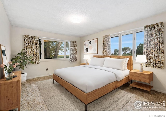 bedroom featuring light colored carpet and a textured ceiling